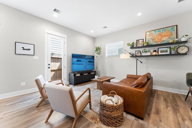 living area featuring recessed lighting, wood finished floors, and visible vents