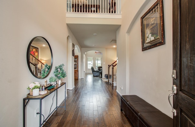 7610 River Pass Dr, Pearland, TX 77581 - foyer entrance with arched walkways, dark wood finished floors, stairs, baseboards, and a towering ceiling