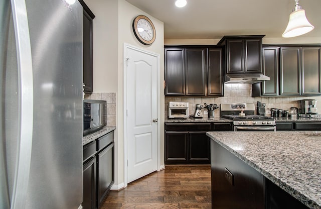 7610 River Pass Dr, Pearland, TX 77581 - kitchen featuring decorative backsplash, appliances with stainless steel finishes, light stone countertops, dark wood finished floors, and under cabinet range hood