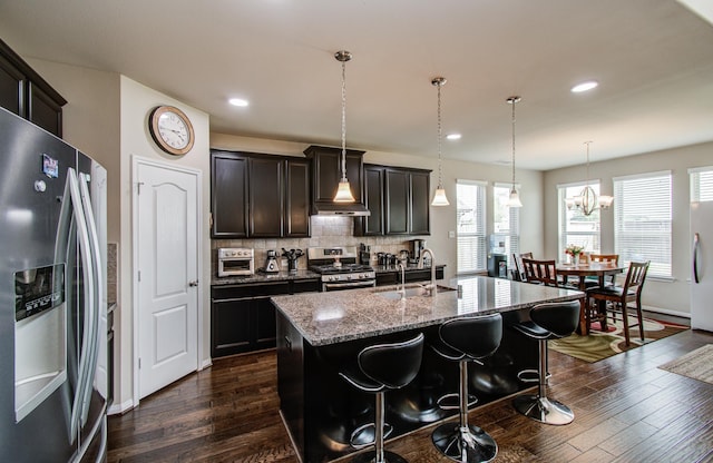 7610 River Pass Dr, Pearland, TX 77581 - kitchen featuring wall chimney range hood, dark wood-style flooring, a sink, light stone counters, and stainless steel appliances