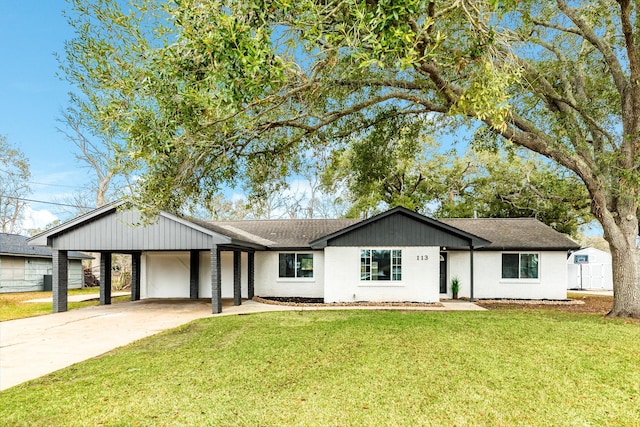 ranch-style house featuring an attached carport, driveway, a shingled roof, and a front lawn