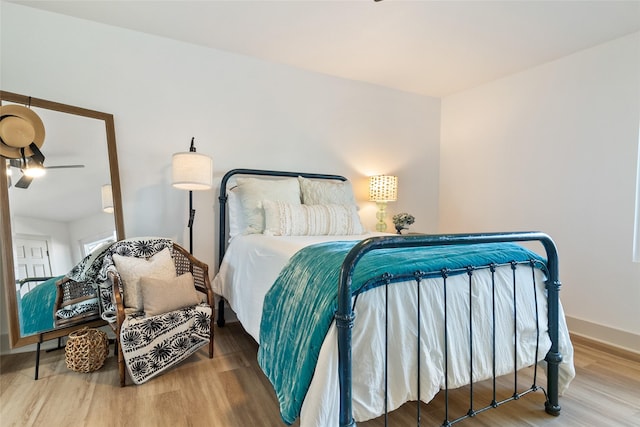 bedroom featuring baseboards and wood finished floors