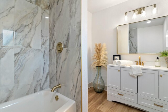 full bath with shower / bath combination, vanity, and wood finished floors