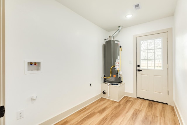 clothes washing area with washer hookup, laundry area, gas water heater, light wood-style flooring, and electric dryer hookup