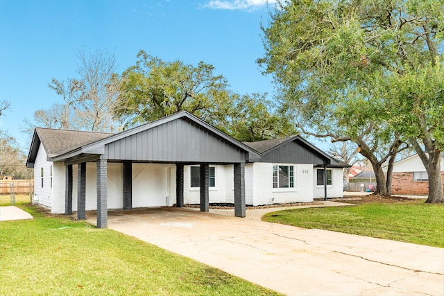 view of front of property with concrete driveway, a front lawn, and brick siding