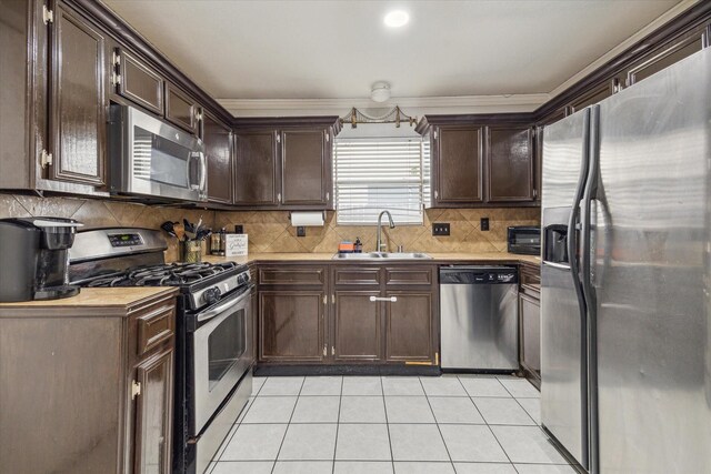 kitchen featuring a sink, light tile patterned floors, dark brown cabinets, and stainless steel appliances