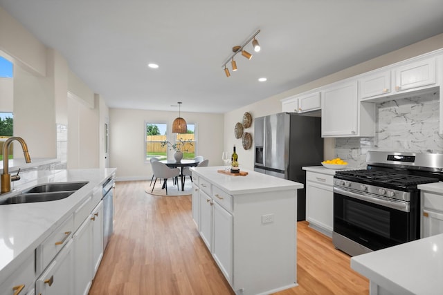 14206 Barker Bayou Ct, Cypress, TX 77429 - kitchen with stainless steel appliances, a sink, tasteful backsplash, white cabinets, and a kitchen island