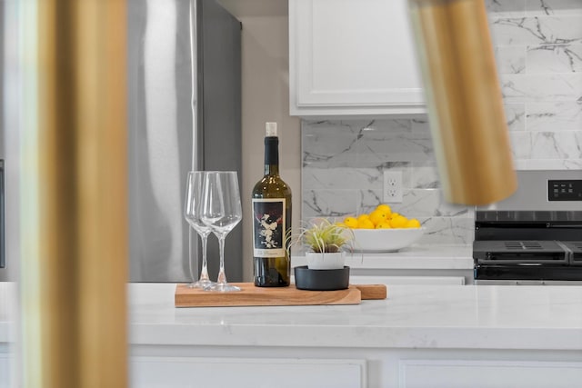 14206 Barker Bayou Ct, Cypress, TX 77429 - kitchen view of decorative backsplash, electric range, and white cabinetry
