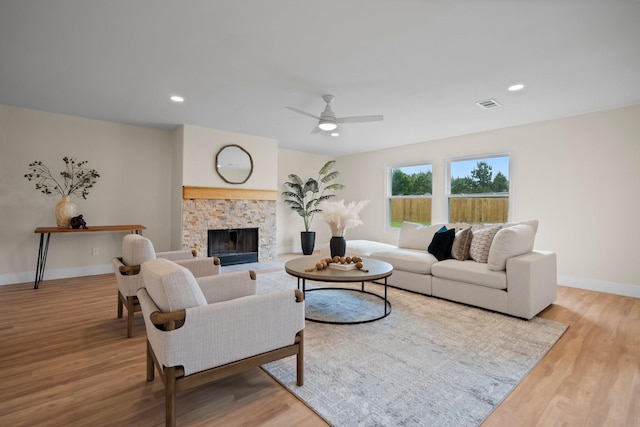 14206 Barker Bayou Ct, Cypress, TX 77429 - living area featuring wood finished floors, a ceiling fan, baseboards, a stone fireplace, and recessed lighting