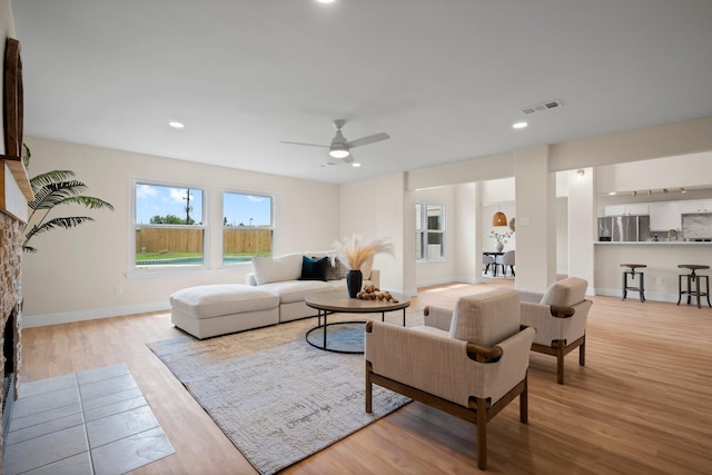 14206 Barker Bayou Ct, Cypress, TX 77429 - living room featuring light wood finished floors, ceiling fan, recessed lighting, baseboards, and a stone fireplace