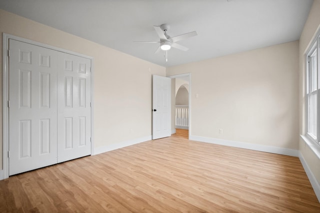 14206 Barker Bayou Ct, Cypress, TX 77429 - unfurnished bedroom featuring wood finished floors, baseboards, arched walkways, and a closet