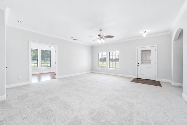 4703 Shadow Grass Dr, Katy, TX 77493 - unfurnished living room with ceiling fan, light carpet, crown molding, healthy amount of natural light, and arched walkways