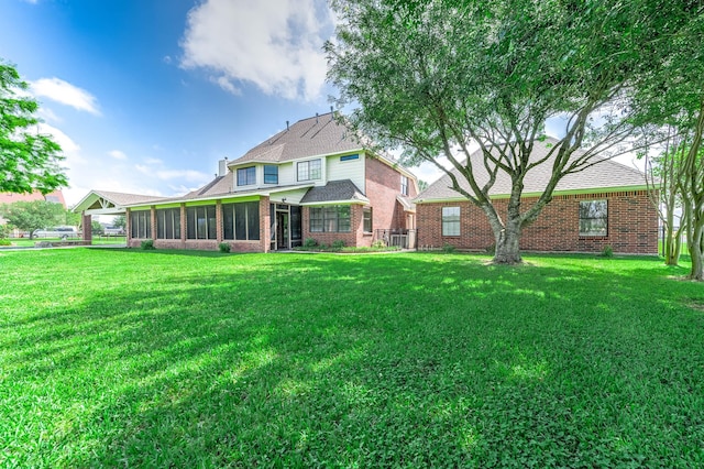 4703 Shadow Grass Dr, Katy, TX 77493 - back of property featuring a yard, brick siding, and a sunroom