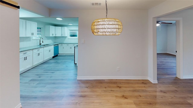 1002 Francis Dr, Pasadena, TX 77506 - kitchen with a sink, dishwashing machine, white cabinetry, a ceiling fan, and tasteful backsplash