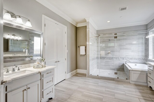 bathroom featuring visible vents, crown molding, vanity, a bath, and a stall shower
