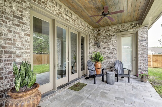 view of patio / terrace with ceiling fan, fence, and french doors