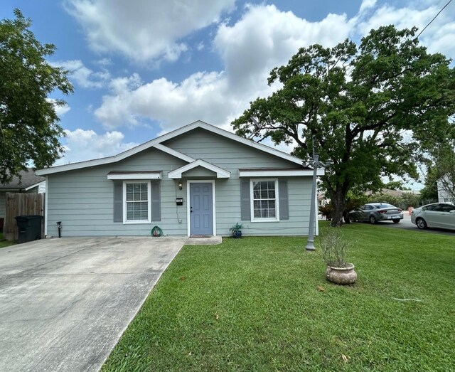 bungalow featuring concrete driveway and a front lawn