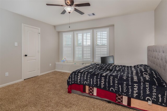 carpeted bedroom featuring baseboards, a ceiling fan, and visible vents