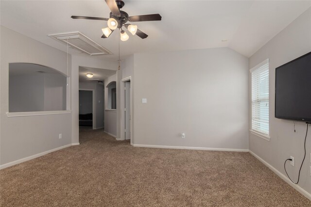empty room featuring a ceiling fan, baseboards, carpet, and attic access