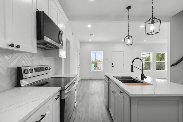 kitchen featuring a sink, light wood finished floors, plenty of natural light, stainless steel appliances, and recessed lighting