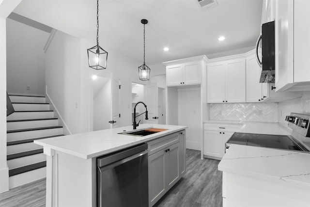 kitchen featuring a sink, stainless steel appliances, recessed lighting, and white cabinetry