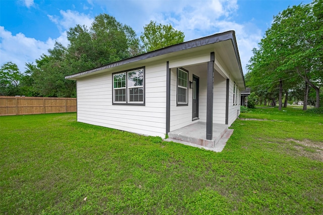 view of home's exterior with fence, a yard, and a patio area