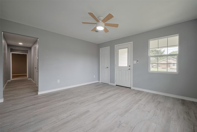 interior space featuring light wood-style floors, baseboards, and ceiling fan