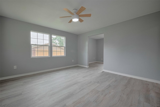empty room with light wood-style floors, baseboards, and a ceiling fan