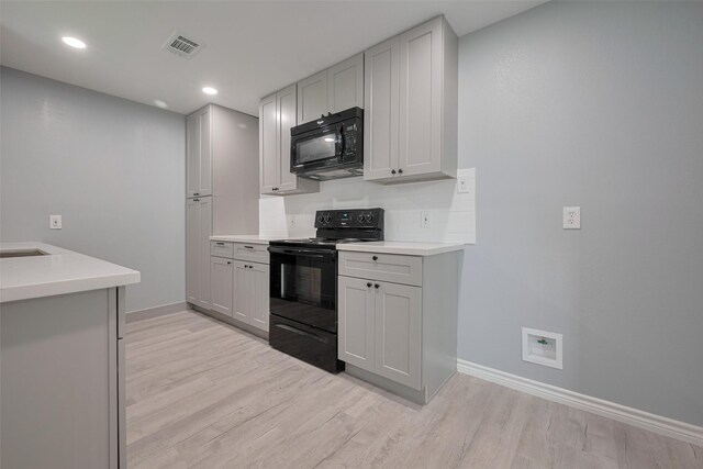 kitchen with baseboards, black appliances, light wood-type flooring, and visible vents