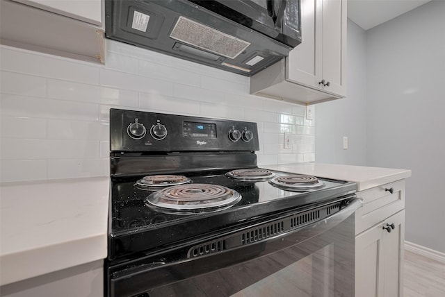 kitchen with light countertops, white cabinetry, tasteful backsplash, and black range with electric stovetop