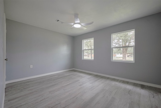 unfurnished room featuring baseboards, ceiling fan, visible vents, and wood finished floors