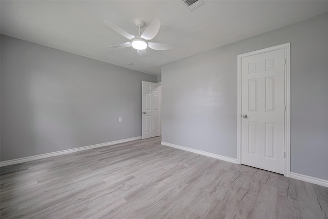 spare room featuring a ceiling fan, baseboards, visible vents, and light wood-type flooring