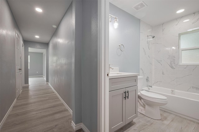 hallway with visible vents, recessed lighting, light wood-style flooring, and baseboards