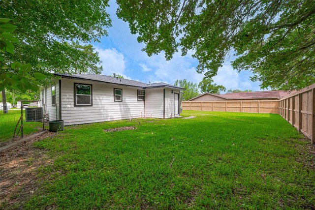 back of property featuring a fenced backyard, central air condition unit, and a lawn