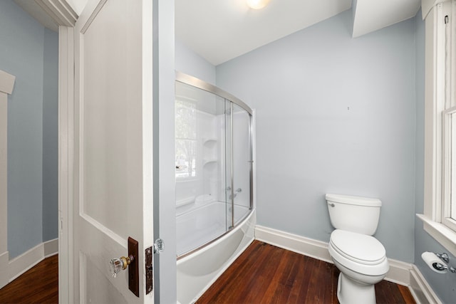 401 Omar St, Houston, TX 77009 - bathroom featuring wood finished floors, toilet, combined bath / shower with glass door, and baseboards