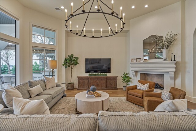 living room with light wood-style floors, visible vents, recessed lighting, and a chandelier