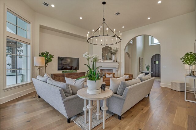 living area with arched walkways, plenty of natural light, and visible vents