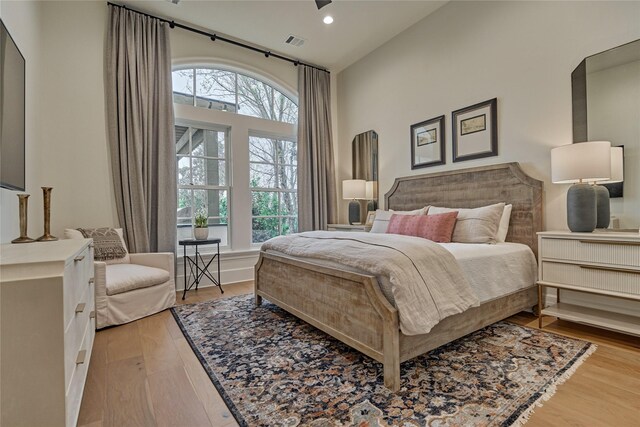 bedroom featuring recessed lighting, high vaulted ceiling, visible vents, and wood finished floors