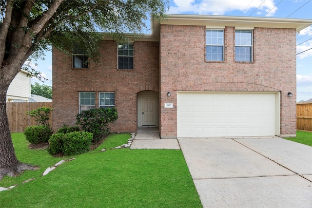 traditional-style home featuring driveway, a front yard, a garage, brick siding, and fence