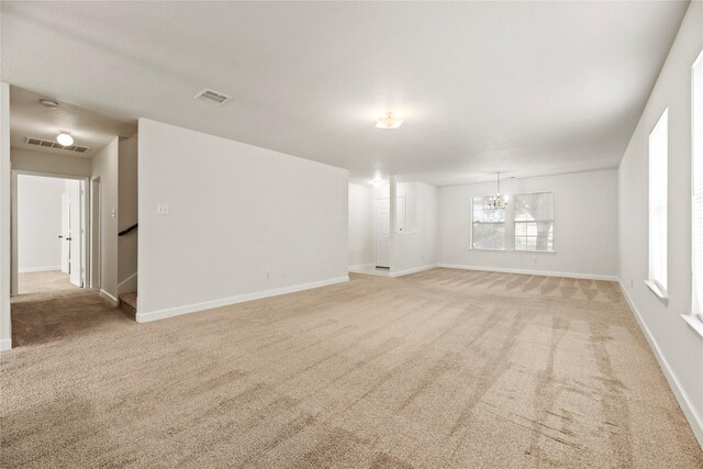 interior space with a notable chandelier, visible vents, and light carpet