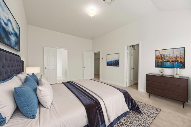 bedroom with baseboards, visible vents, light carpet, and a towering ceiling