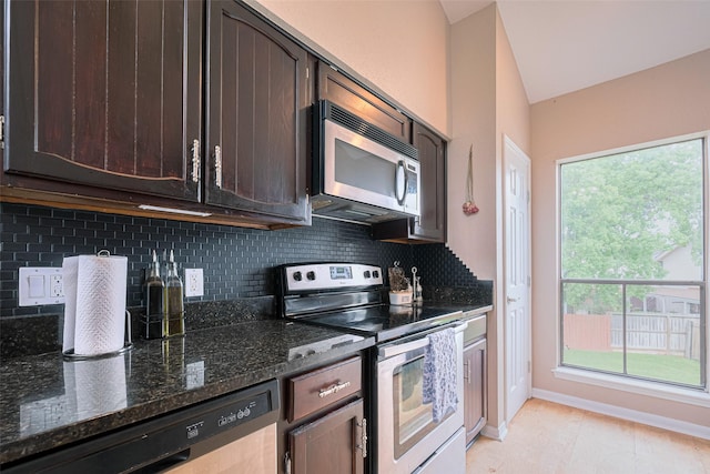 182 April Point Dr N, Conroe, TX 77356 - kitchen with dark brown cabinets, baseboards, dark stone counters, tasteful backsplash, and stainless steel appliances