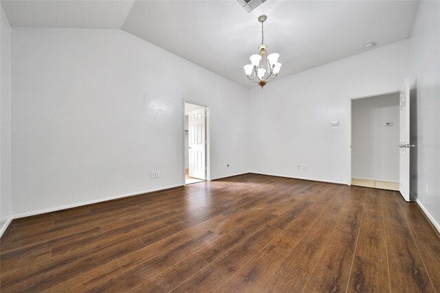 spare room with a chandelier, visible vents, wood finished floors, baseboards, and lofted ceiling