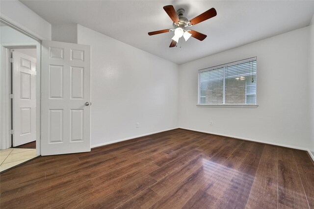 empty room featuring baseboards, a ceiling fan, and wood finished floors