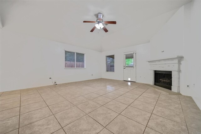 unfurnished living room featuring a fireplace with raised hearth, ceiling fan, and light tile patterned flooring