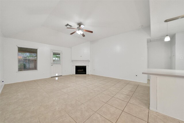 unfurnished living room with ceiling fan, visible vents, light tile patterned floors, and lofted ceiling