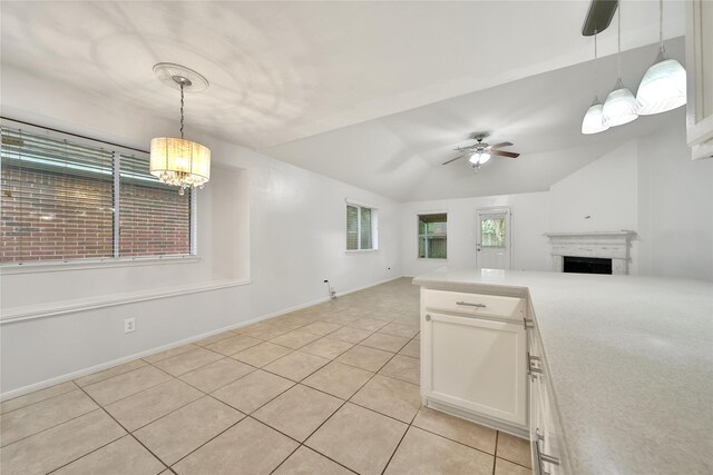 kitchen with lofted ceiling, light tile patterned flooring, a fireplace, open floor plan, and light countertops