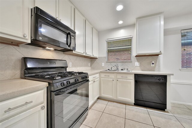 kitchen with light countertops, a sink, black appliances, and white cabinets