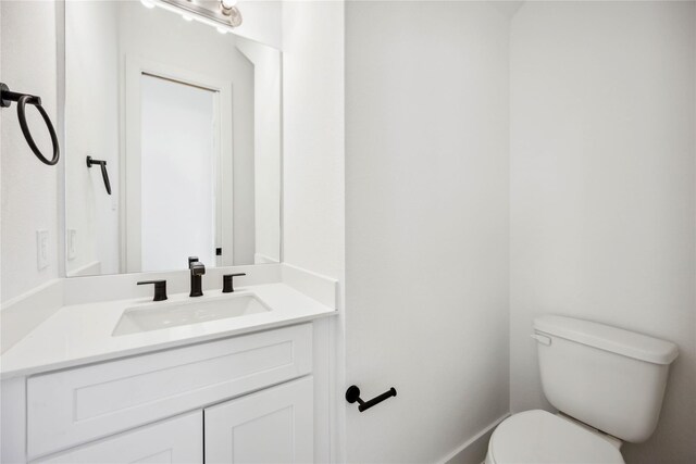 half bathroom with vanity and toilet