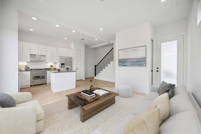 living area featuring stairway, baseboards, light wood finished floors, and recessed lighting